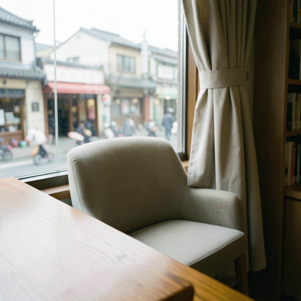 Close view of a library window seat, a wooden table, and daylight from a town street.
